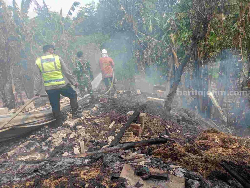 Petugas Damkar BPBD Kabupaten Mojokerto memadamkan api yang membakar kandang sapi di Desa Jetis, Kecamatan Jetis, Kabupaten Mojokerto. [Foto : ist]