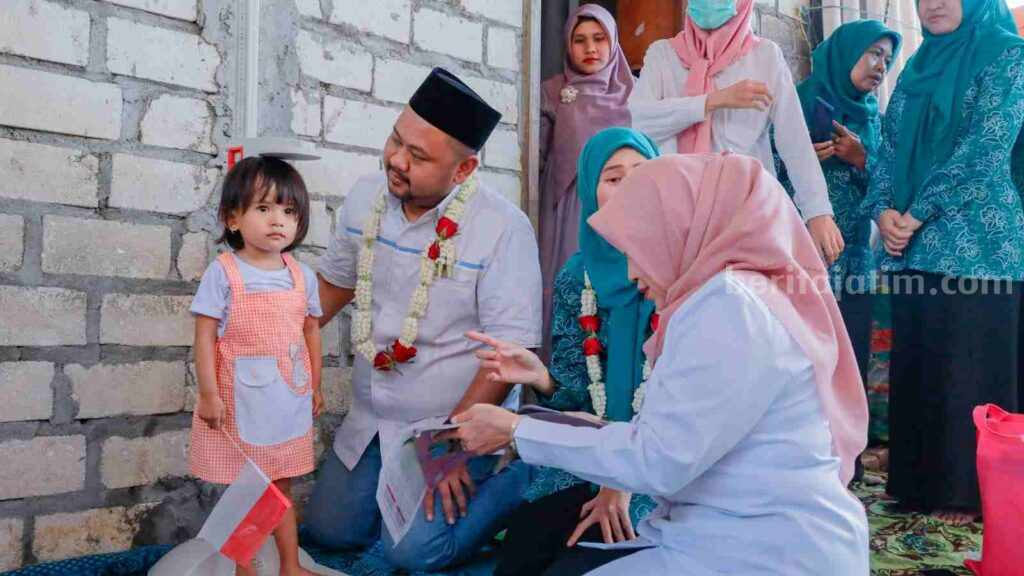 Foto seorang balita dihibur usai mendapat asupan gizi untuk mencegah stunting.