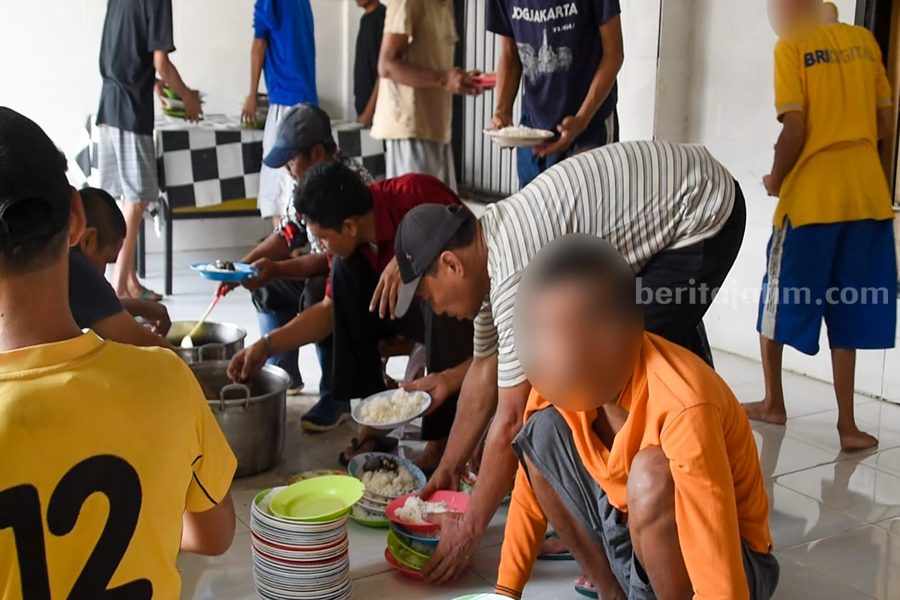 AB (baju putih garis-garis) saat memberi makan ODGJ di Liponsos Keputih, Minggu (26/11/2023).