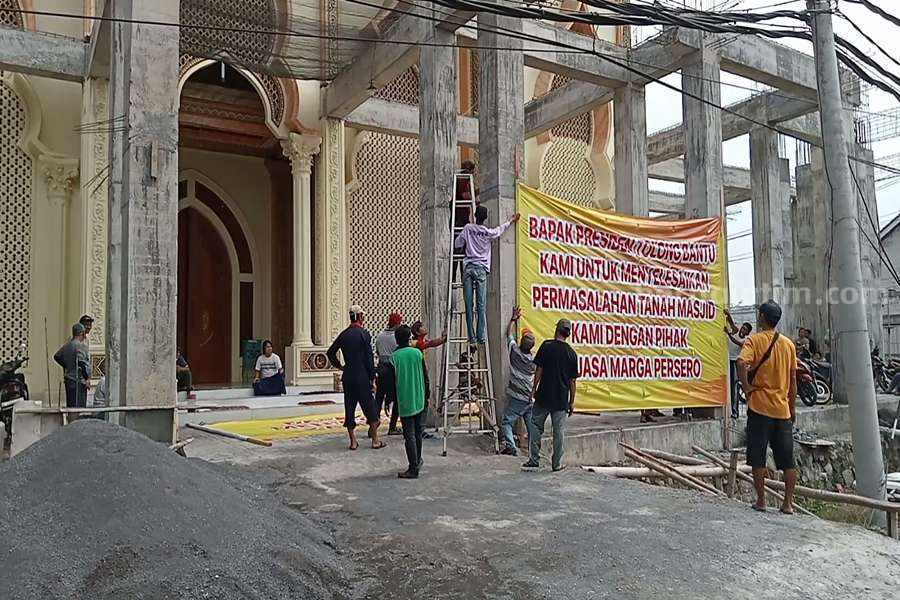 Sejumlah warga Dusun Kesemi saat memasang baliho di depan masjid Al-Ikhlas.