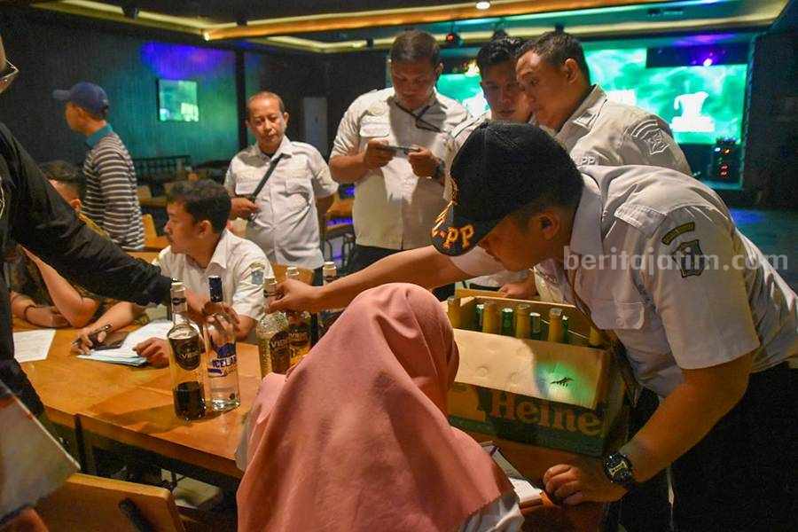 Petugas melakukan pengecekan pada minuman keras yang dijual di Chug Bar, Kamis (30/11/2023). (Foto/ist).