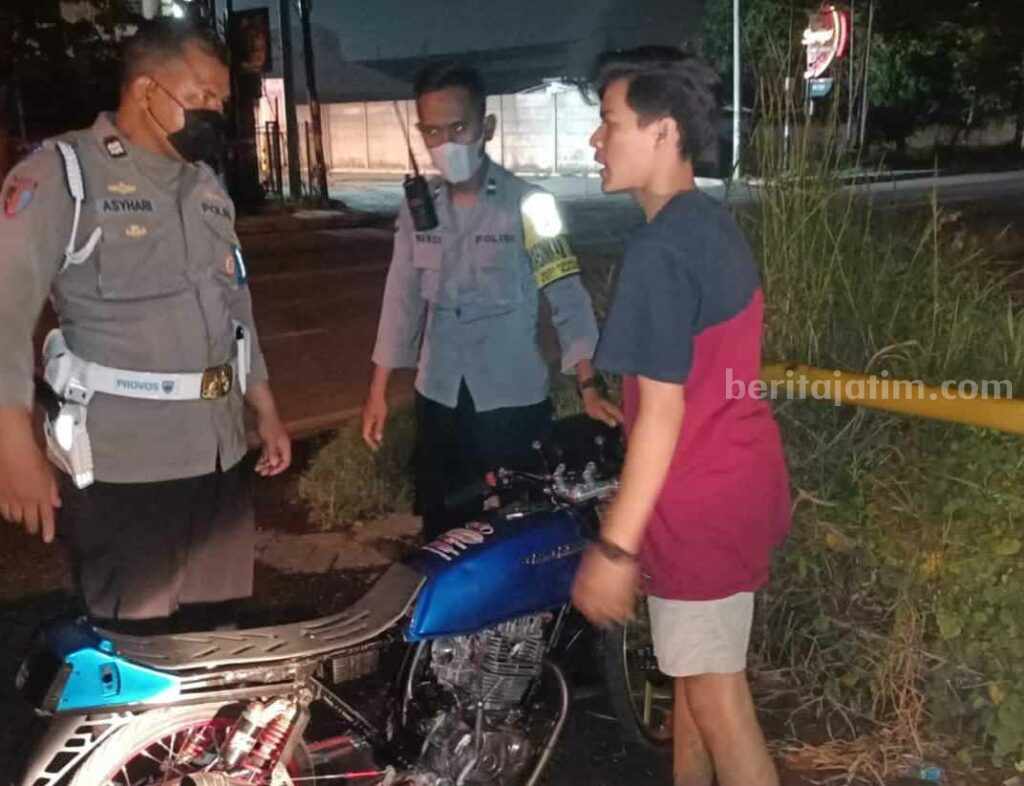 Foto dua orang polisi sedang melakukan razia terhadap pengendara motor untuk menekan kriminalitas di jalan raya