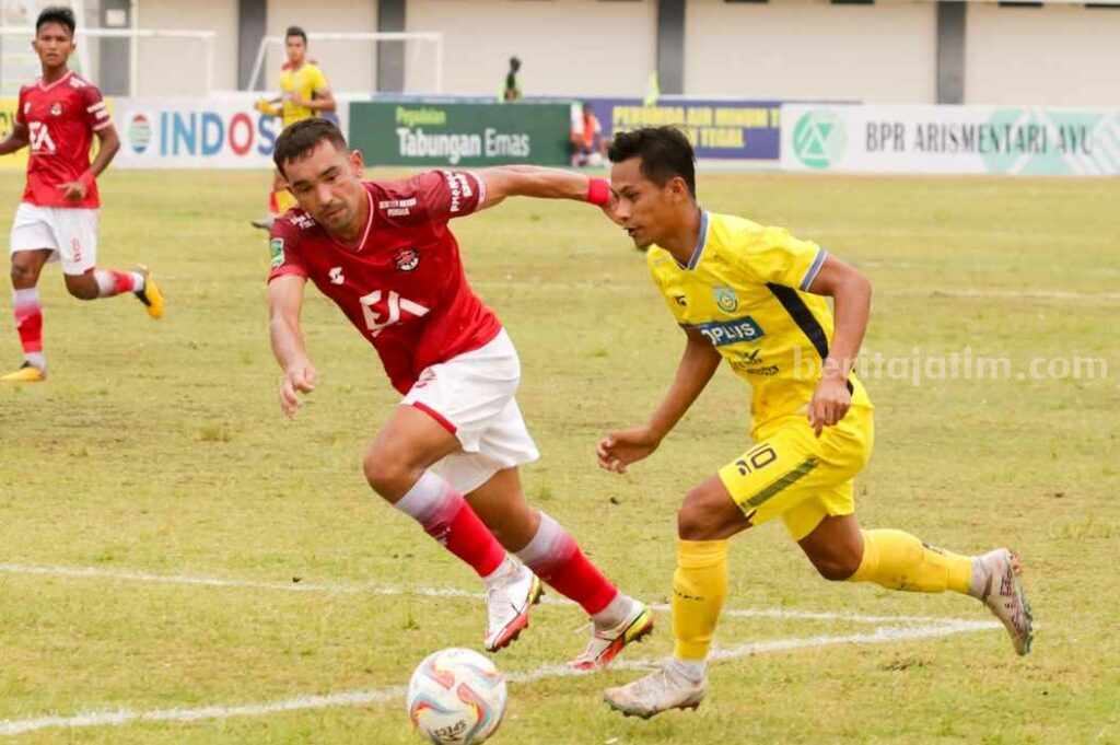 pemain Gresik United M.Faisol dibayangi oleh pemain belakang Persekat Tegal