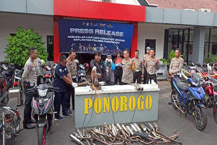 Proses pemusnahan knalpot brong dengan dipotong menggunakan gerinda listrik. (Foto/Endra Dwiono/Beritajatim.com)