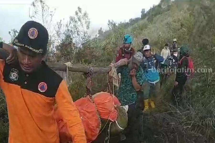 Foto : Petugas dan sejumlah warga saat mengangkat dua jenazah kecelakaan pesawat yang berada di Kecamatan Lumbang, Kabupaten Pasuruan. (Istimewa)