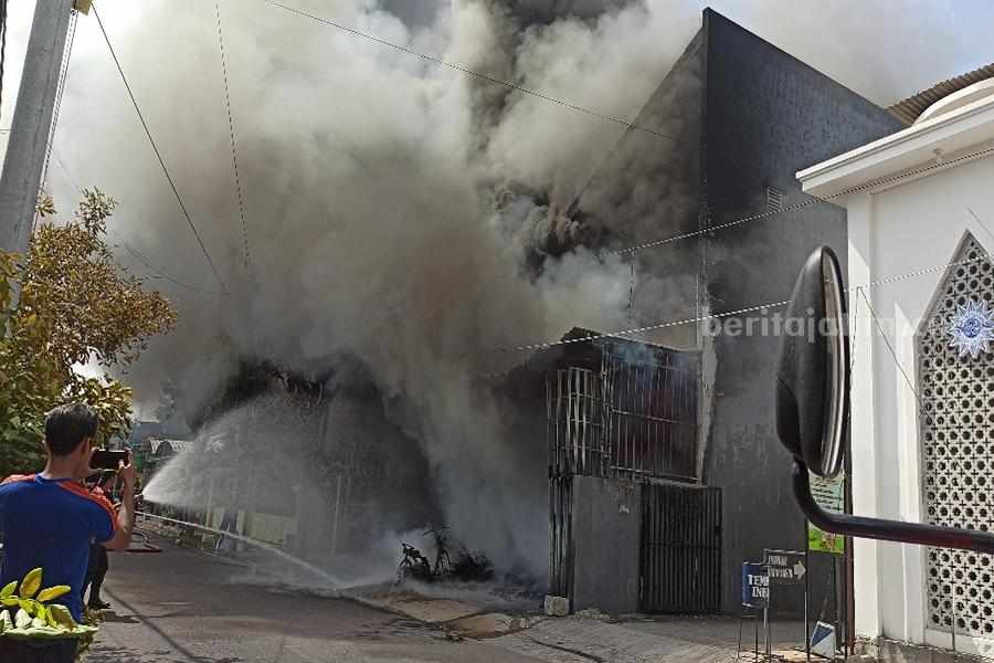 Petugas melakukan pemadaman di bangunan toko gerabah di jalan Banda Ponorogo. (Foto/Endra Dwiono/Beritajatim.com)
