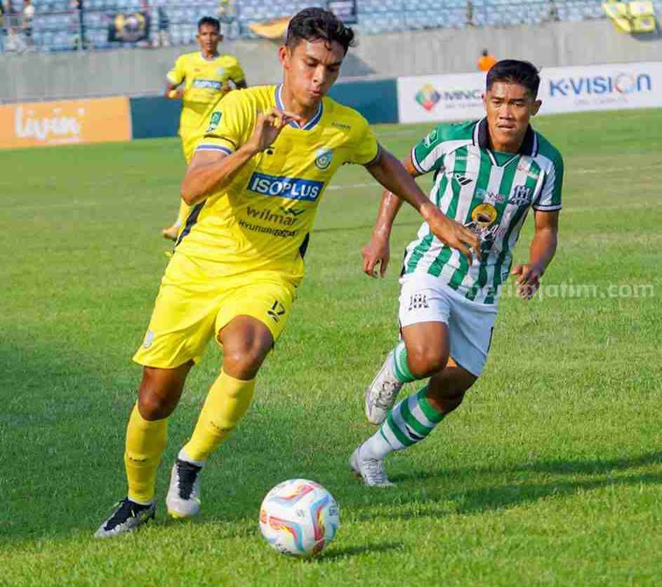 Foto pemain Gresik United M.Ridwan (kostum kuning) dibayangi pemain Deltras FC