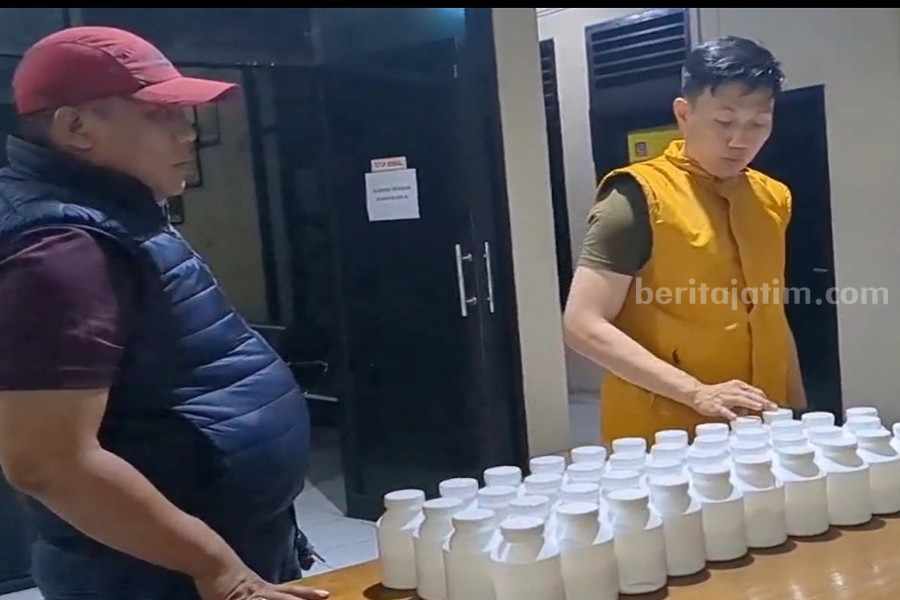 Miliki 41 Ribu Pil Koplo, Bandar Dukuh Pakis Digulung Polisi Kapolsek Karangpilang, Kompol Risky Fadian (kanan) saat menghitung barang bukti yang diamankan dari AS dan AM.