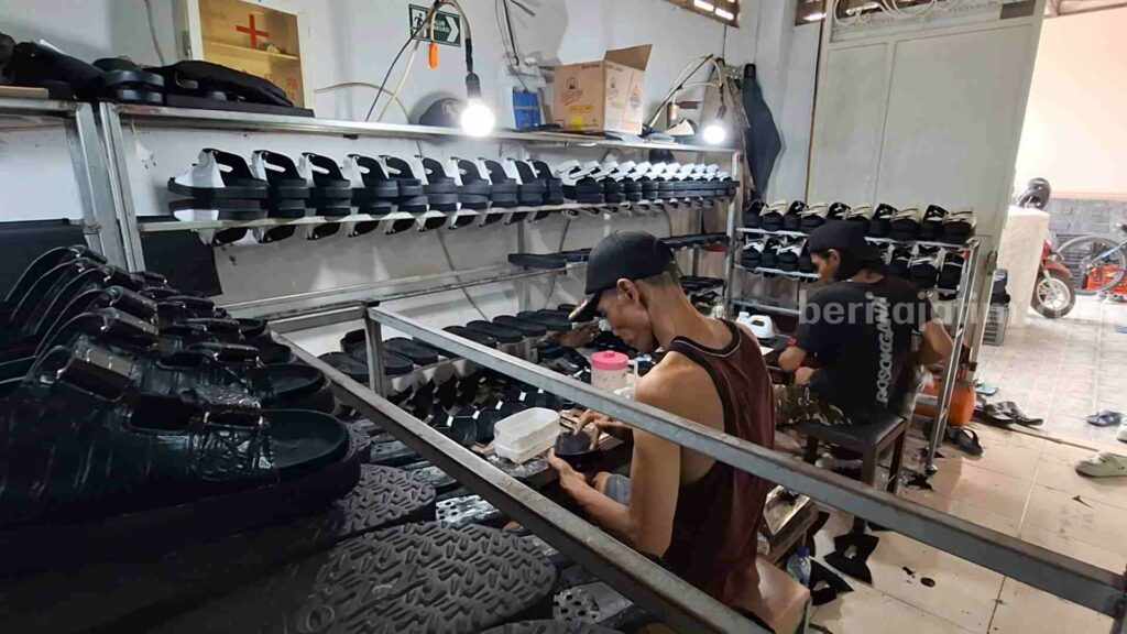 Moch Yani sedang bekerja sebagai pengrajin sandal di tempat produksi sandal miliknya. [Foto : Misti/beritajatim.com]
