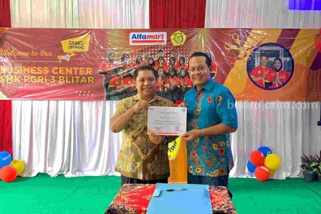 Sugiharto, Wakil Kepala Cabang PT Sumber Alfaria Trijaya (SAT) Malang memberikan bukti hibah bisnis center kepada kepala SMK PGRI 3 Kota Blitar.