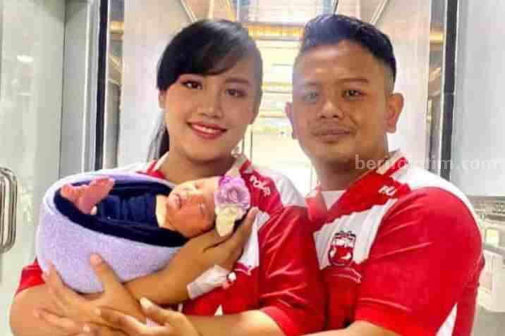 Pasutri suporter Madura United menggendong 'Cinta Madura United'.