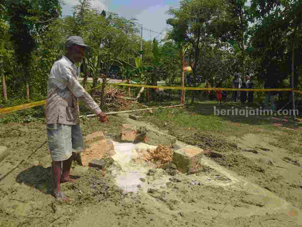 Samirin sedang menunjuk mulut sumur bor yang berada didepan rumahnya saat menyembur air.