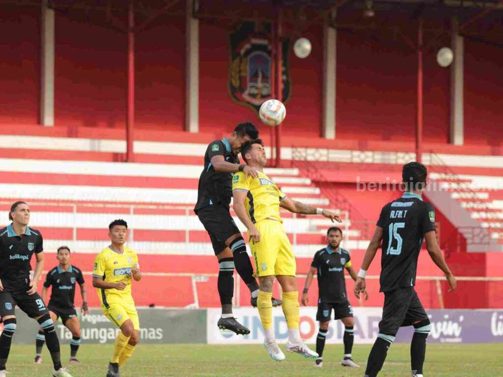 Pemain Gresik United Jepri Kurniawan (kuning) duel udara dengan pemain Pe