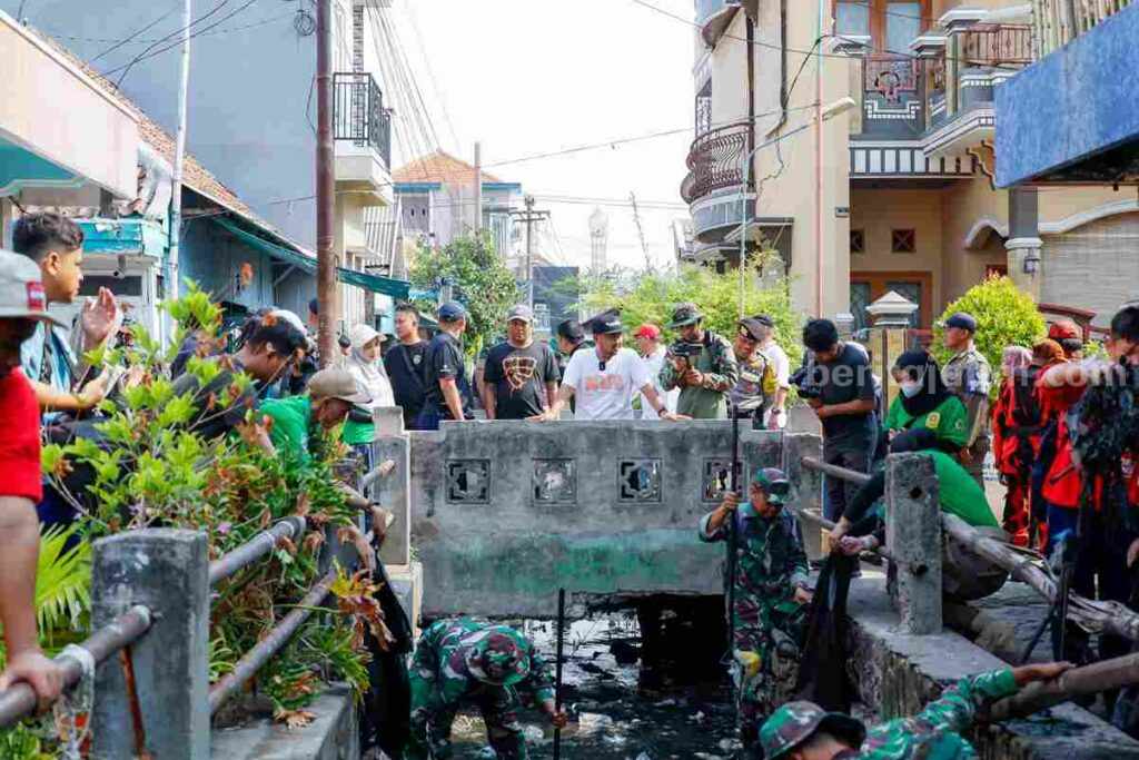 Warga bersama anggota TNI dan Polri melakukan bersih-bersih saluran air di area pasar