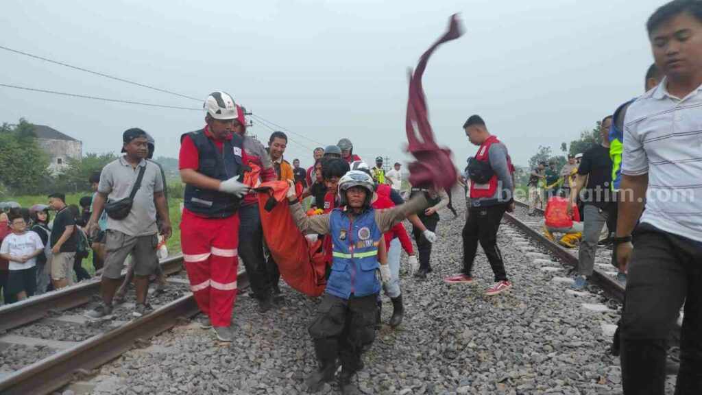 Sejumlah relawan mengevakuasi jasad korban dari rel Kereta Api (KA) di Underpass lingkungan Tropodo, Kelurahan Meri, Kecamatan Kranggan, Kota Mojokerto. [Foto : ist]