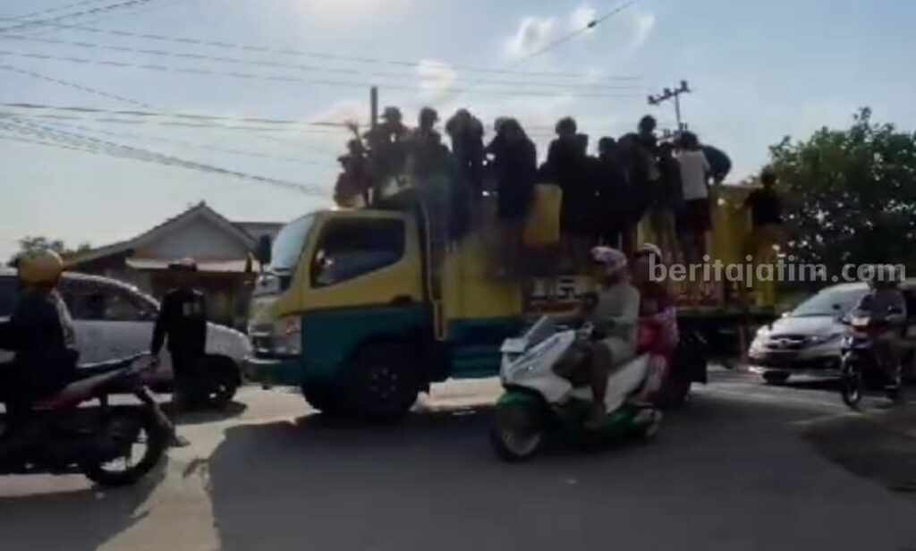 Aksi nekat para remaja yang menyetop truk untuk ditumpangi di jalan raya jembatan Suramadu (Foto: Zamachsari/beritajatim.com)