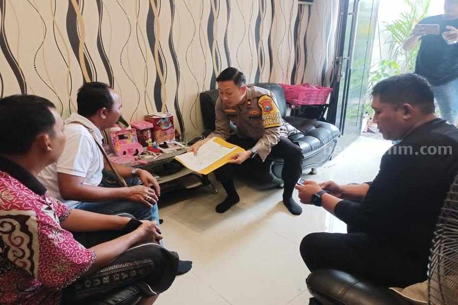 Kapolsek Karang Pilang, Kompol Risky Fardian saat menyerahkan surat perintah penangkapan kepada orang tua salah satu gangster All Star KBD. (Foto/dok Polsek Karangpilang).