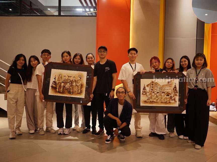 Mahasiswa VCD Universitas Ciputra Surabaya menunjukkan hasil lukisan dari ampas kopi.