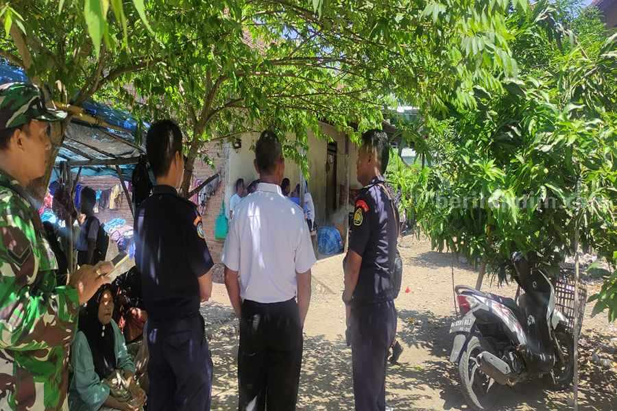 Petugas saat melakukan evakuasi terhadap nelayan yang sudah di tepian pantai.