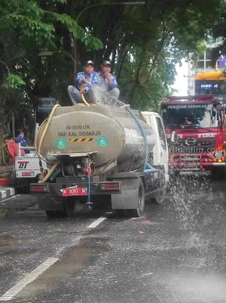 Petugas DLHK membersihkan sampah yang ditumpahkan para demonstran