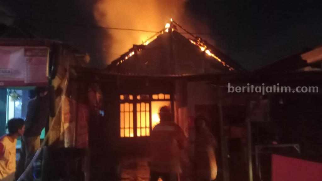 Foto petugas Damkarla Gresik berjibaku memadamkan rumah warga yang dilalap api.