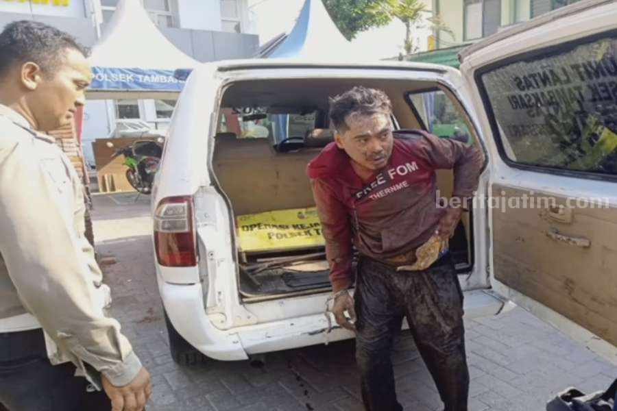 SP (baju merah) saat diamankan oleh anggota Polsek Tambaksari di halaman kantor, Senin (11/12/2023). (Foto/ist)
