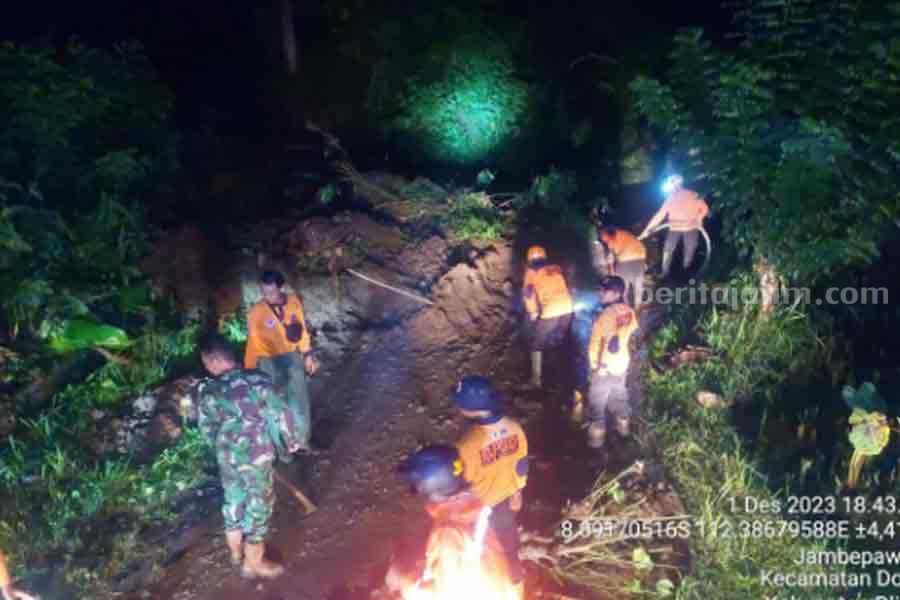Petugas BPBD Kabupaten Blitar melakukan pembersihan material longsor.