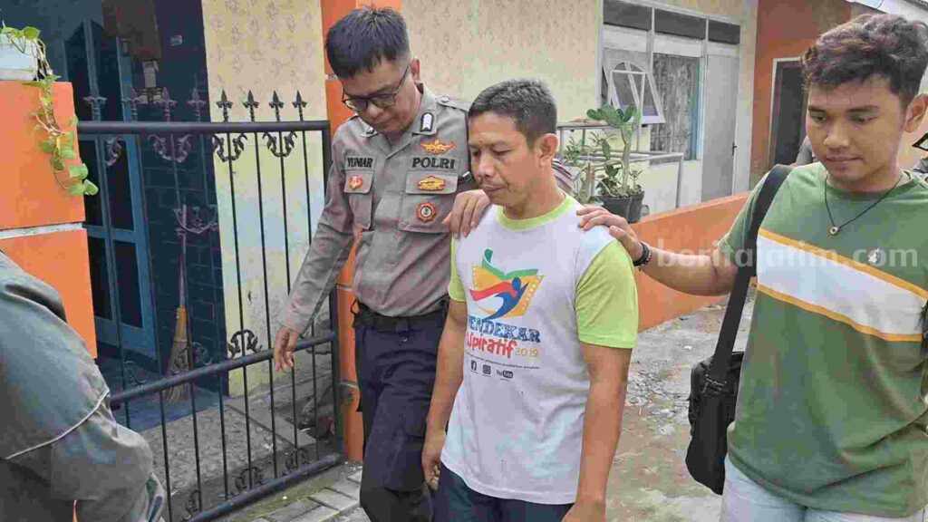 Caption : Pelaku, Sutomo (53) saat diamankan dari dalam rumahnya. [Foto : Misti/beritajatim.com]
