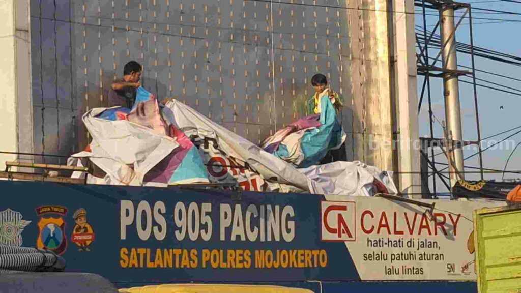 TKD Prabowo-Gibran Kabupaten Mojokerto melepas baliho ATK di atas Pos 905 Pacing Satlantas Polres Mojokerto. [Foto : Misti/beritajatim.com]