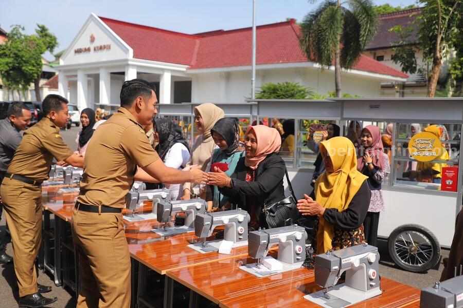 Caption : Bupati Tuban Aditya Halindra Faridzky saat menyerahkan bantuan mesin jahit dan gerobak.
