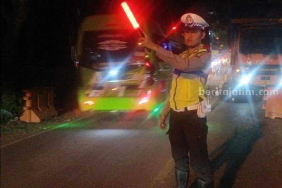Petugas kepolisian saat membantu mengatur arus lalin di Jembatan Klampis (Foto: Zamachsari/beritajatim.com)