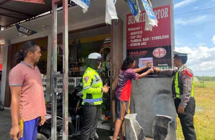Anggota Satlantas Polres Sumenep tempelkan stiker ke bengkel