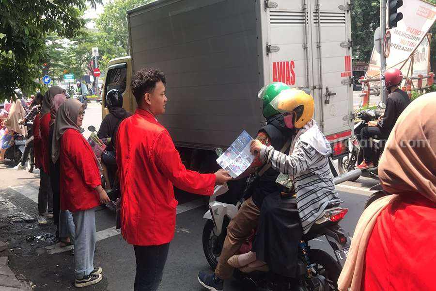 Aksi mahasiswa bagi-bagi pamflet Tolak Pelanggar HAM dan Politik Dinasti.
