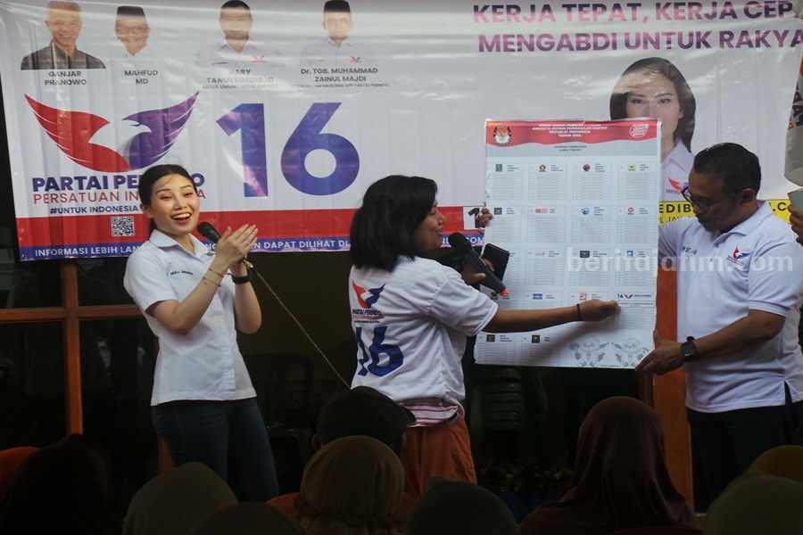 Angela menyaksikan warga praktek mencoblos yang benar