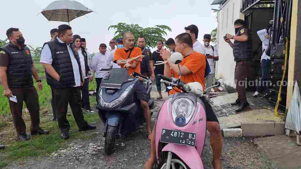 Foto dua tersangka pembunuhan sadis (berbaju oranye) sedang memperagakan adegan rekonstruksi