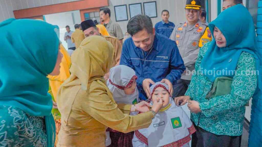 Seorang anak yang duduk di sekolah dasar mendapatkan imunisasi polio