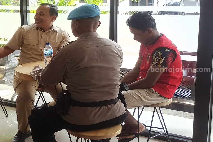Pelaku (rompi merah-red) duduk sambil menundukkan kepala, saat menunggu press release kasusnya. (Foto/Endra Dwiono/Beritajatim.com)