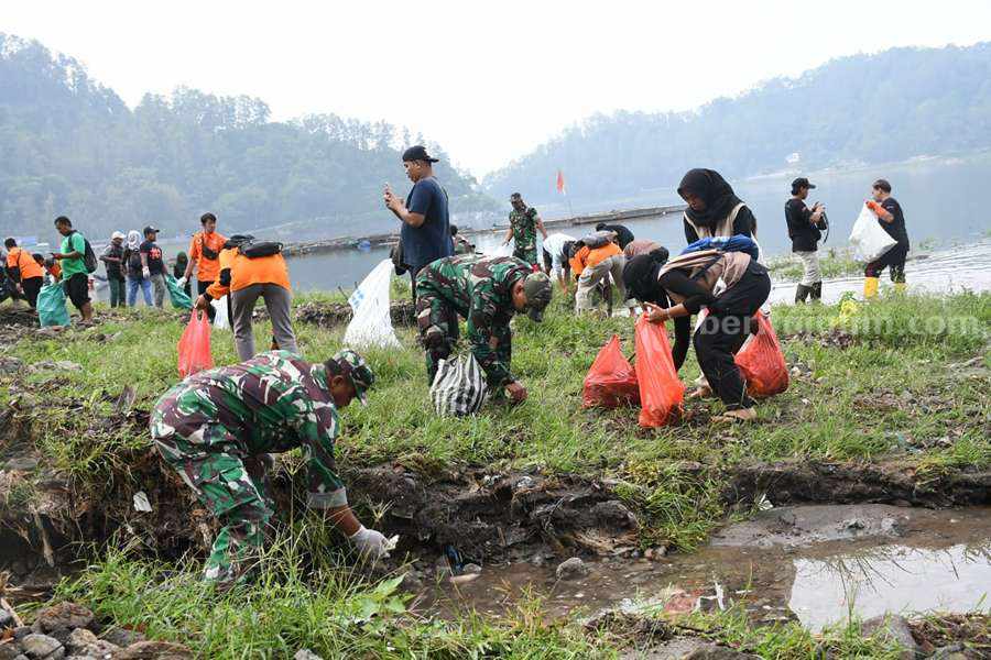 Aksi bersih-bersih ratusan relawan di kawasan wisata Telaga Ngebel Ponorogo. (Foto/Kodim 0802 Ponorogo)