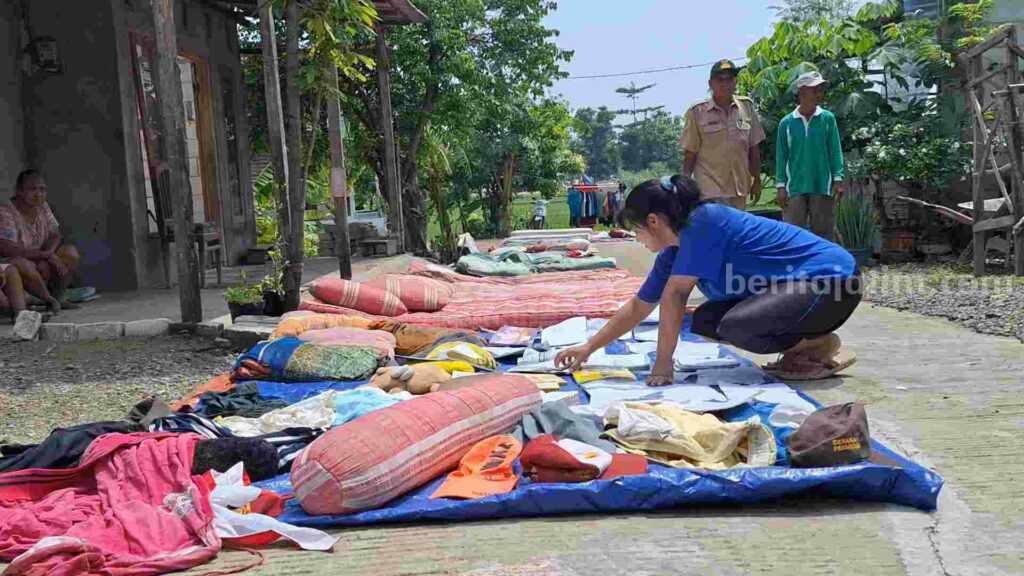 Warga Desa Pandan Krajan, Kecamatan Kemlagi, Kabupaten Mojokerto menjemur kasur dan buku pasca bencana angin puting beliung. [Foto : ist]
