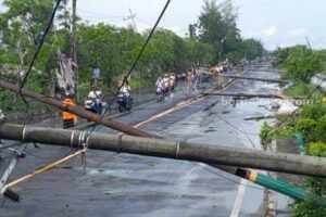 11 Tiang Listrik Roboh Akibat Angin Puting Beliung, Jalur Utama Sumenep-Pamekasan Dialihkan Kondisi tiang listrik roboh timpa jalan raya akibat puting beliung. (tem)