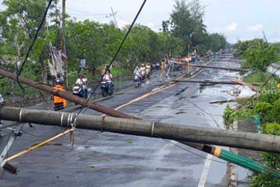 11 Tiang Listrik Roboh Akibat Angin Puting Beliung, Jalur Utama Sumenep-Pamekasan Dialihkan Kondisi tiang listrik roboh timpa jalan raya akibat puting beliung. (tem)