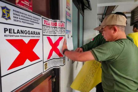 Petugas Satpol PP Surabaya saat melakukan penyegelan.