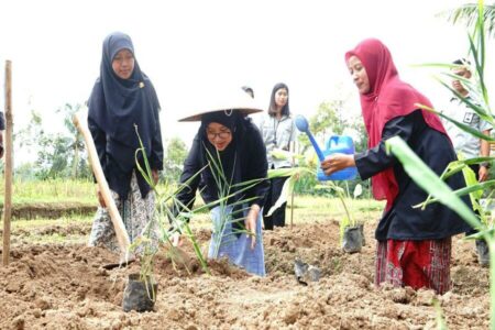 Bupati Banyuwangi Ipuk Fiestiandani saat ikut menanam tanaman herbal dan obat di Desa Segobang, Kecamatan Licin di sela program Bunga Desa. (humaskab)