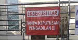 Benner yang dipasang di pagar rumah sengketa