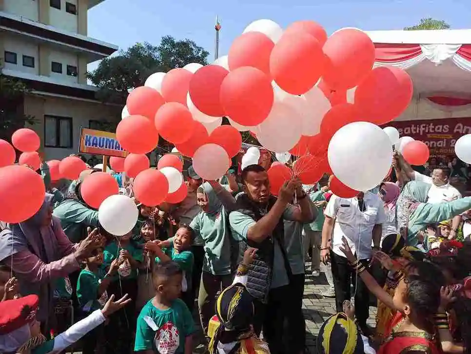 Bupati Ponorogo Sugiri Sancoko dan istri membagikan balon kepada anak-anak di halaman Gedung Terpadu.(foto/Endra Dwiono/Beritajatim.com)