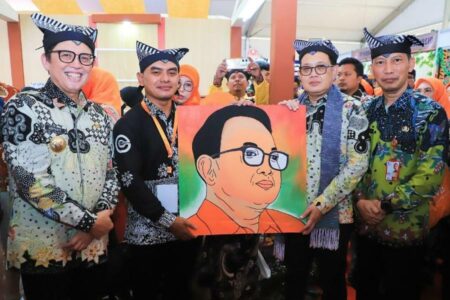Adib Nurdiyanto saat menyerahkan lukisan hasil daur ulang limbah pewarna batik menjadi cat serbaguna kepada PJ Gubernur Jawa Timur Adhy Karyono. [Foto: Istimewa]