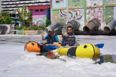Peneliti ECOTON saat mengambil sampel air di Sungai Kalidami Surabaya yang mengeluarkan busa. [Foto: ECOTON]