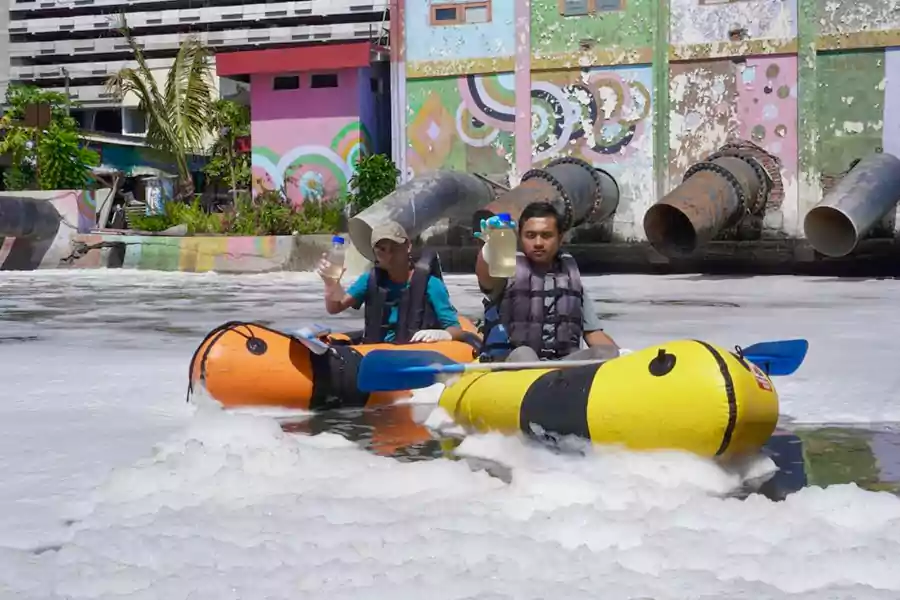 Peneliti ECOTON saat mengambil sampel air di Sungai Kalidami Surabaya yang mengeluarkan busa. [Foto: ECOTON]