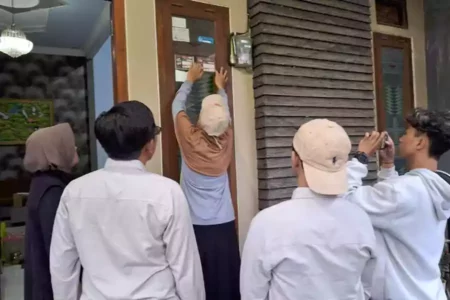 Puluhan Stiker Coklit Tak Sesuai Spesifikasi KPU Terpasang di Blitar Pantarlih memasang stiker Coklit di rumah warga Kabupaten Blitar, Jumat (28/06/2024). (Foto: Winanto/beritajatim.com)