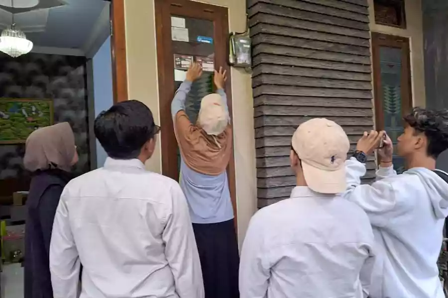 Pantarlih memasang stiker Coklit di rumah warga Kabupaten Blitar, Jumat (28/06/2024). (Foto: Winanto/beritajatim.com)